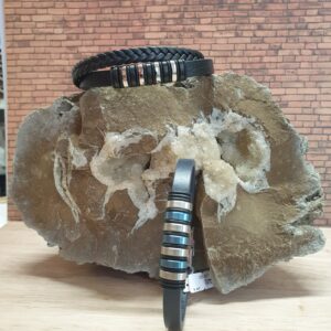 Bracelet acier et cuir Thabora, en couleur noir ou bleu posés sur une grosse pierre